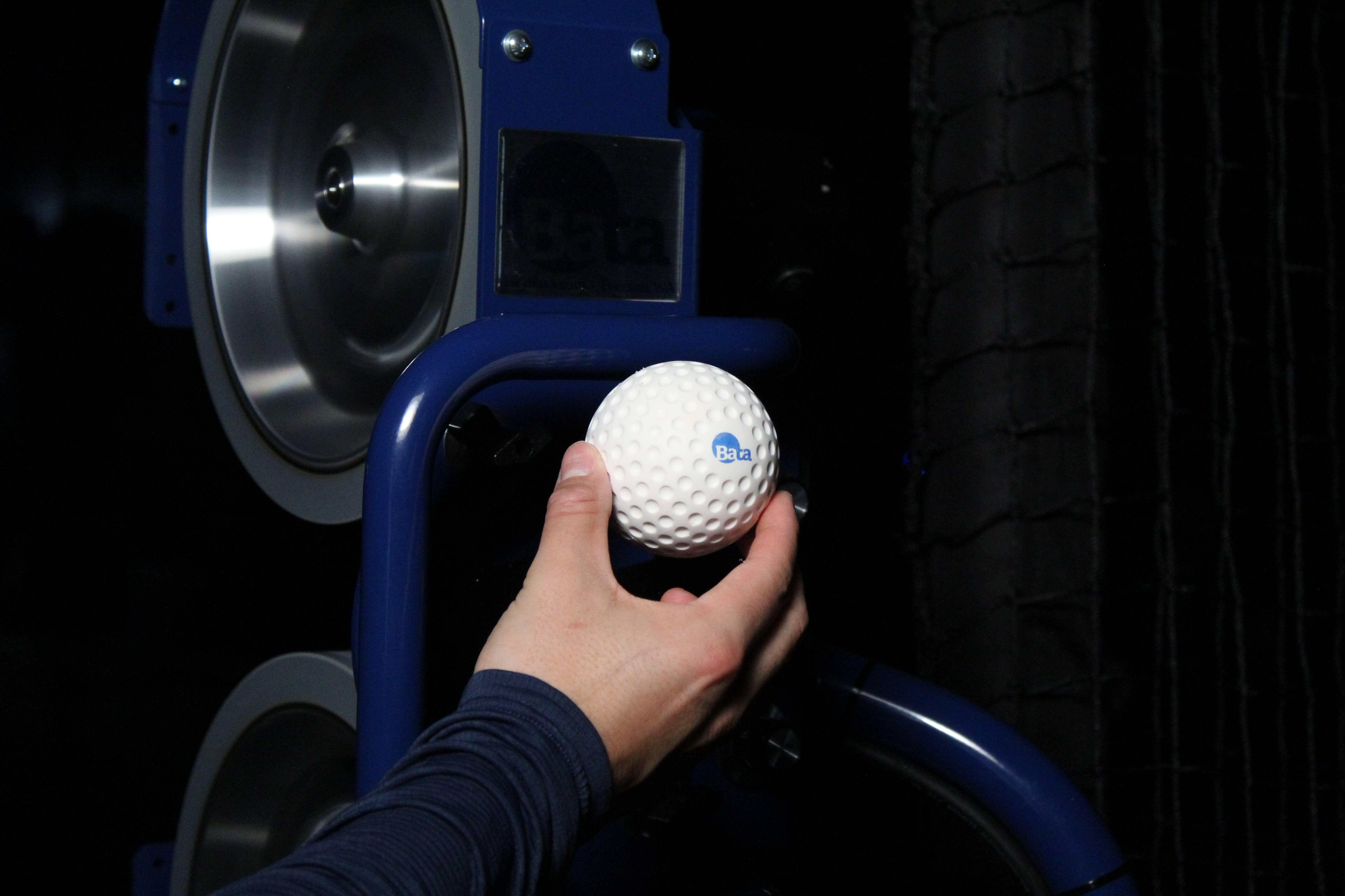Man feeding lightweight bata baseballs into the bata 2 machine