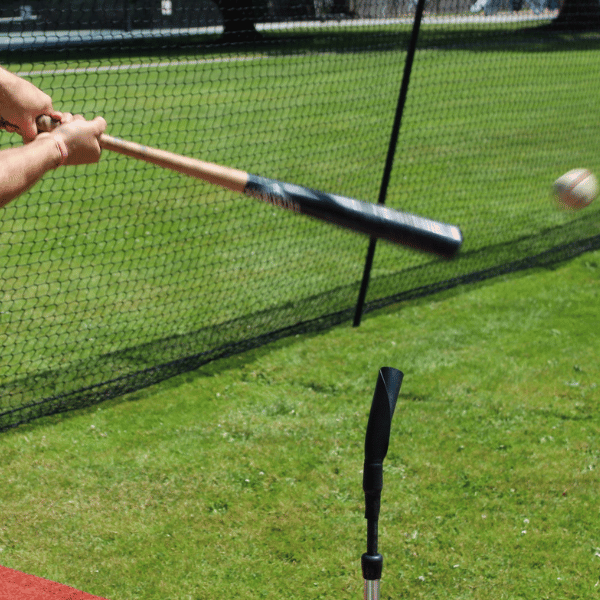 Man hitting a baseball off of the tanner tee