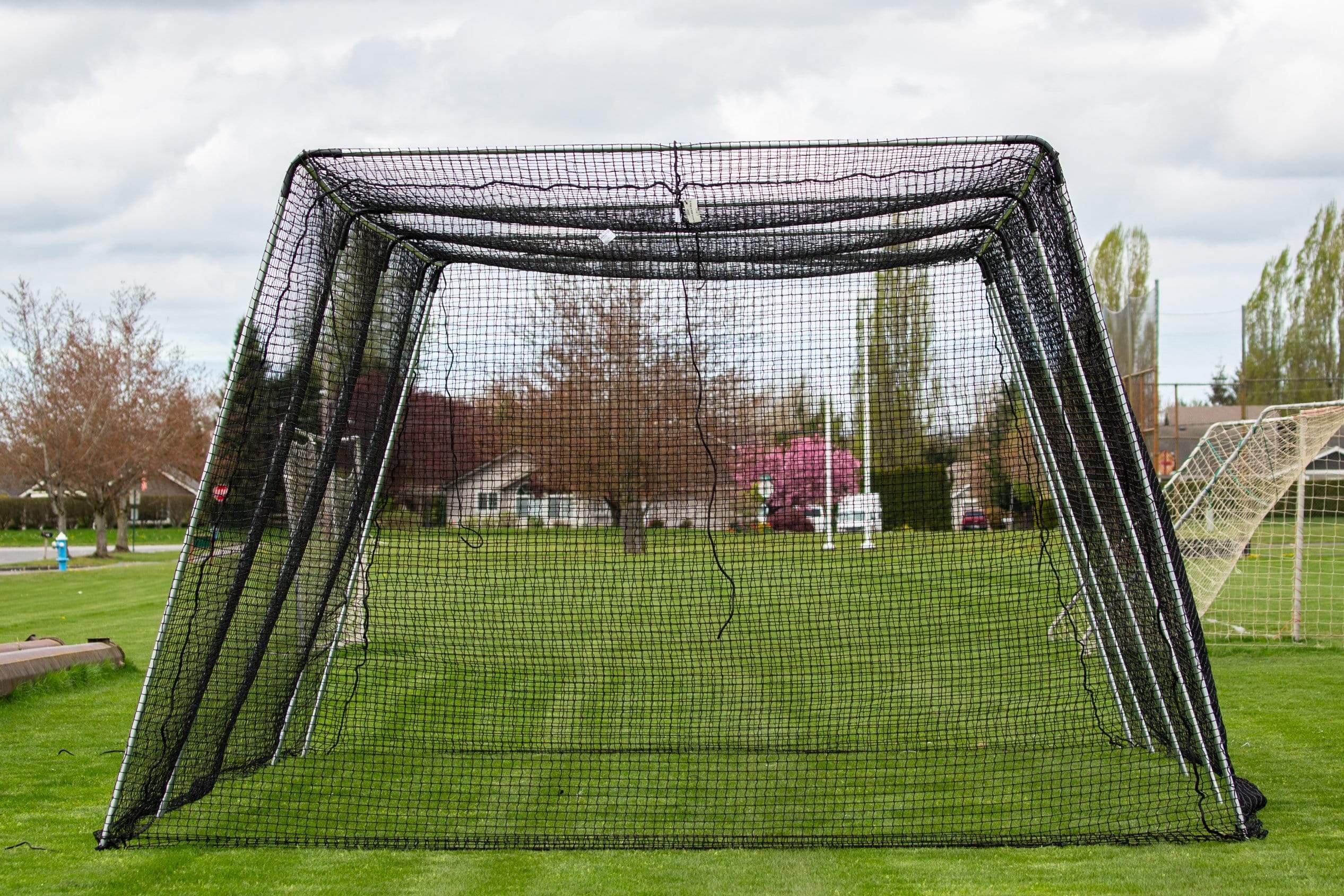 Freestanding Trapezoid Batting Cage on field grass