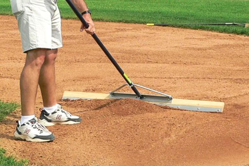 Man using Level Board to clean up baseball infield