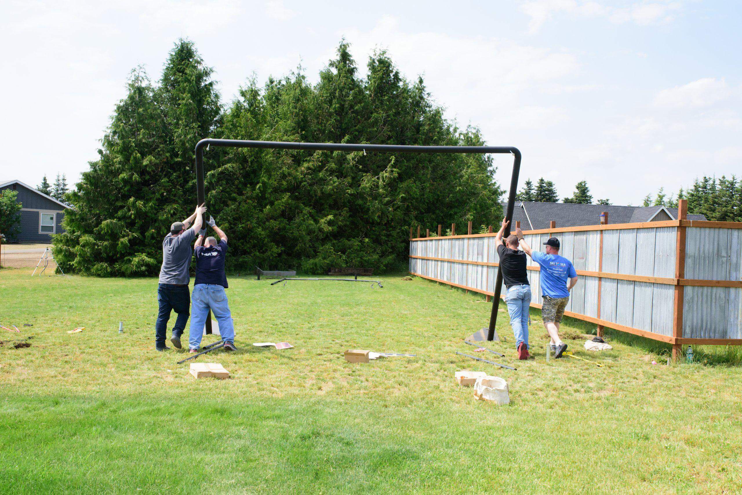 four men standing up the iron horse frame end