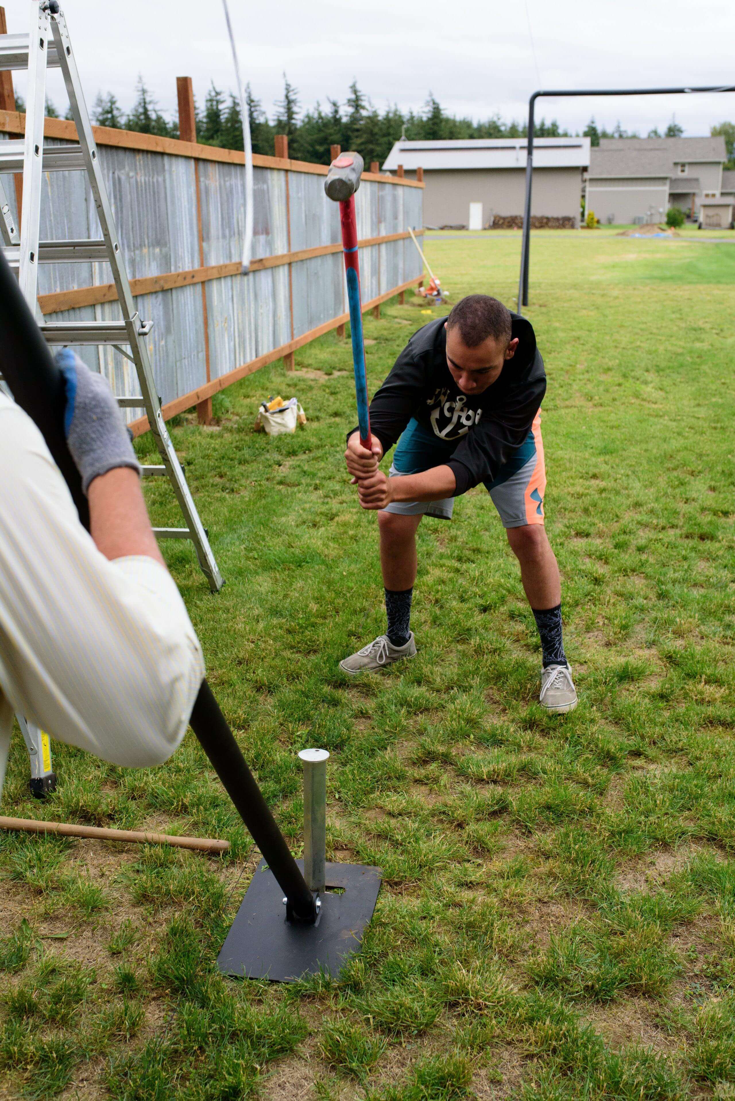 man hammering in the heavy duty sleeves for Iron Horse system