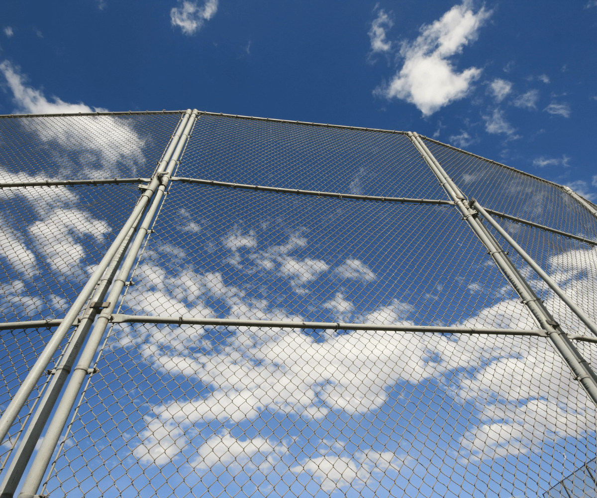 Backstop fencing up close with blue skies
