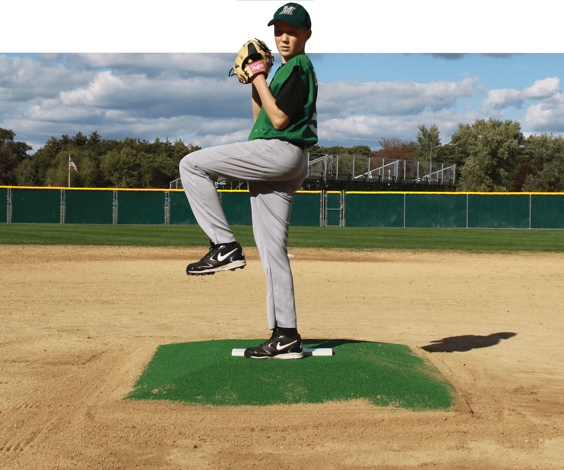 Boy pitching on a mound in baseball infield