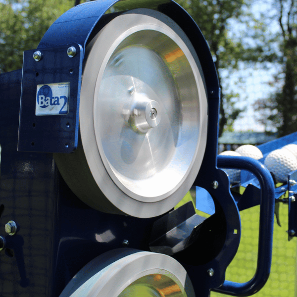 Close up of the Bata 2 pitching machine wheel and auto feeder feeding balls into it