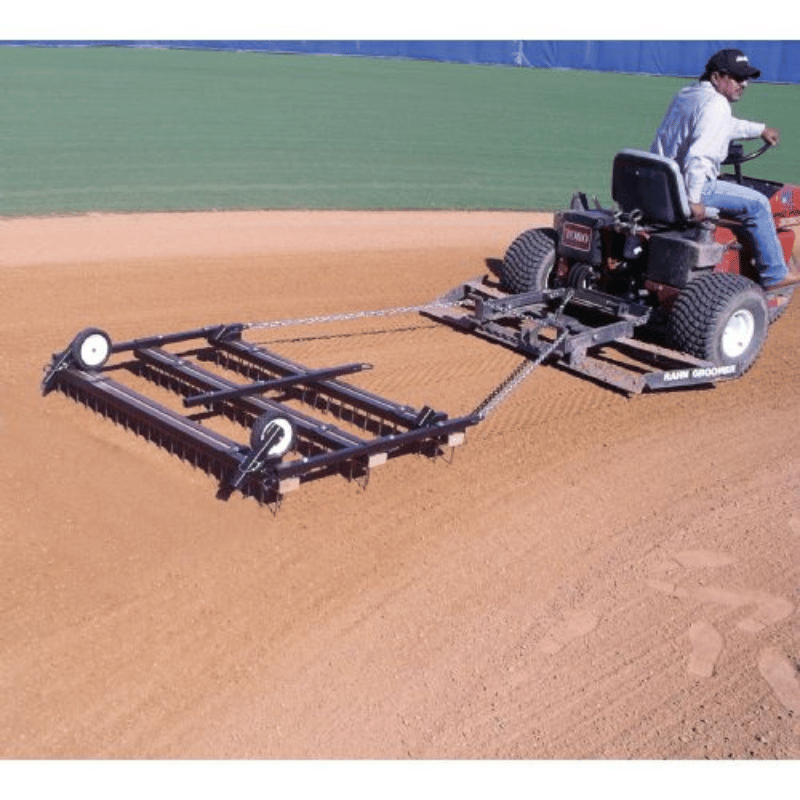 Man on mower driving through the baseball infield with the 5ft x 3ft Premium Nail Drag